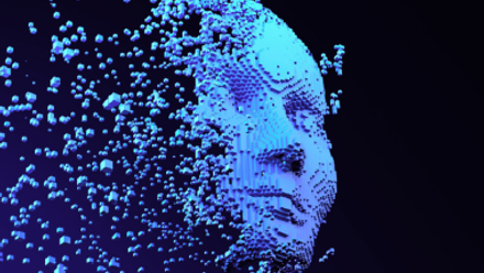 Abstract blue digital human face formed from pixels, partially dissolving into floating particles against a dark background.