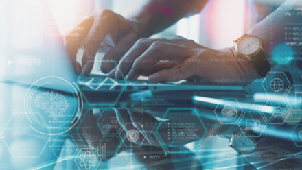 Close-up of hands typing on a laptop with overlaid digital data graphics, symbolising technology, innovation, and digital transformation.