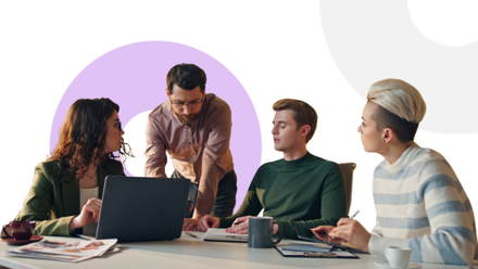 Four colleagues gathered around a table in discussion, with laptops and notebooks, on a white background with lavender geometric shapes.