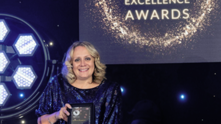 Rebecca Nicholls holding her winning trophy for the Memcom Excellence Awards