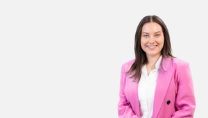 A profile photo of Ellen Culhane with long brown hair and wearing a white shirt and pink jacket.